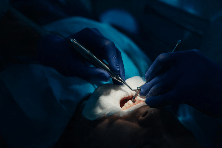 Fotografia em estilo editorial, close-up das mãos enluvadas de um dentista segurando com cuidado um instrumento próximo à boca de um paciente